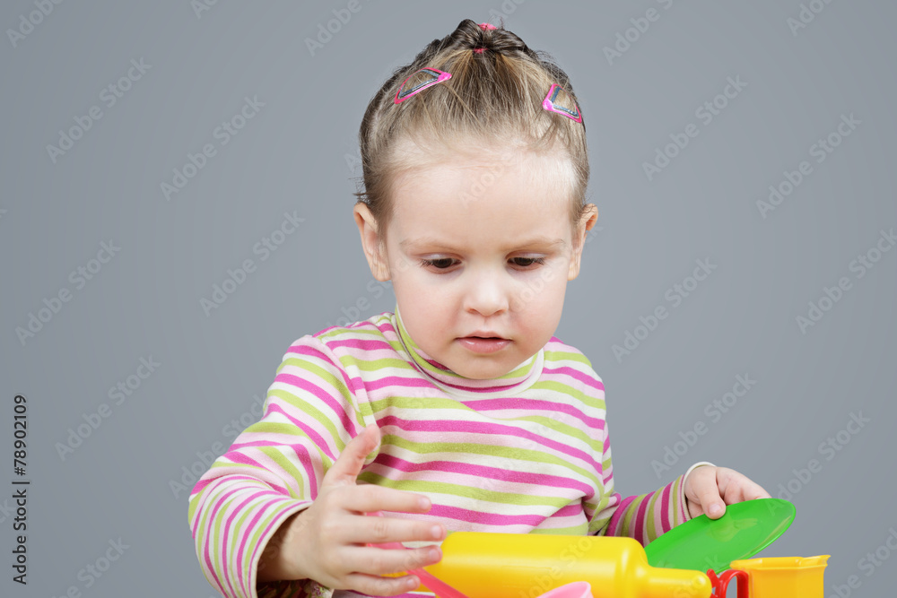 Girl playing with plastic tableware