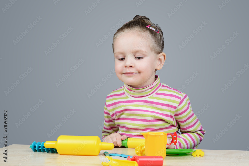 Girl playing with plastic tableware