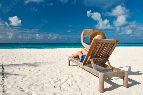 Young woman reading a book at beach