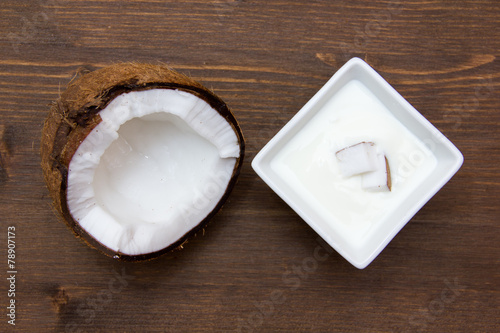 Yogurt with coconut on wood from above