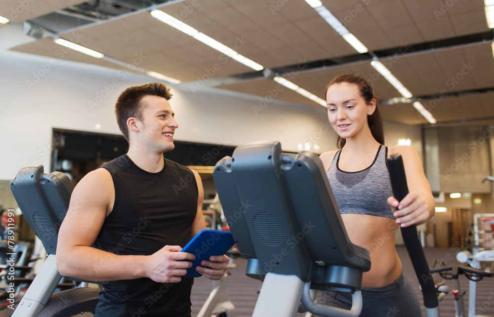 woman with trainer exercising on stepper in gym woman with trainer exercising on stepper in gym