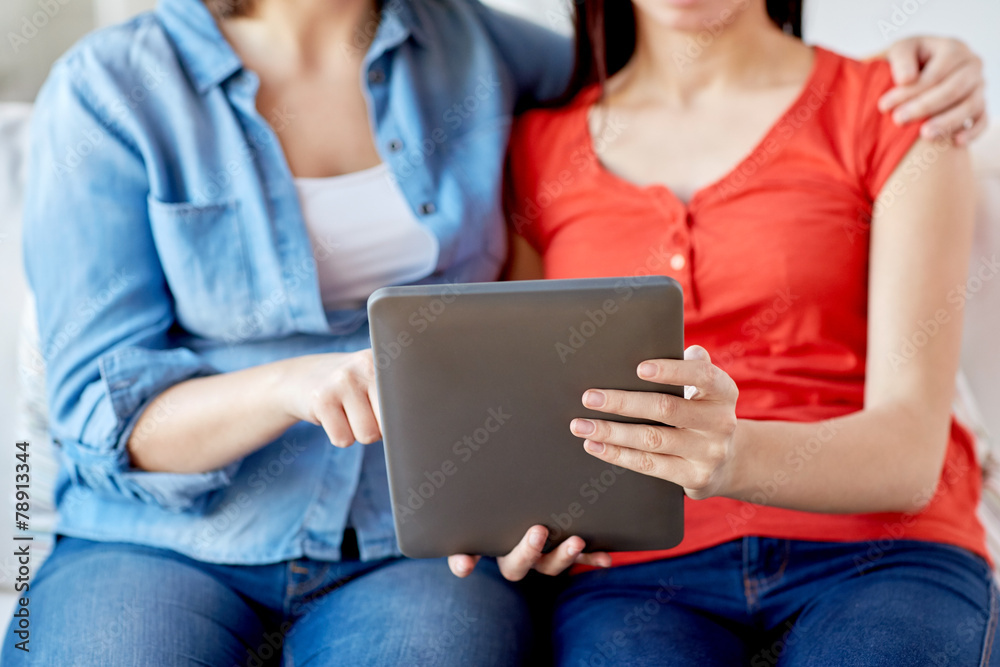Naklejka premium close up of lesbian couple with tablet pc at home