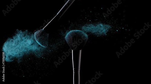 Blue powder explosion with 2 beauty brushes