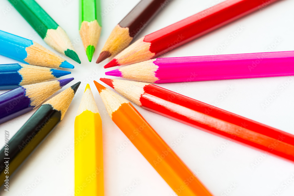 Colored pencils in a circle on the paper in corner. Angle view Colored pencils in a circle on the paper in corner. Angle view