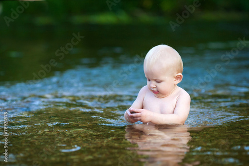 The child is bathing in the river © zarraza