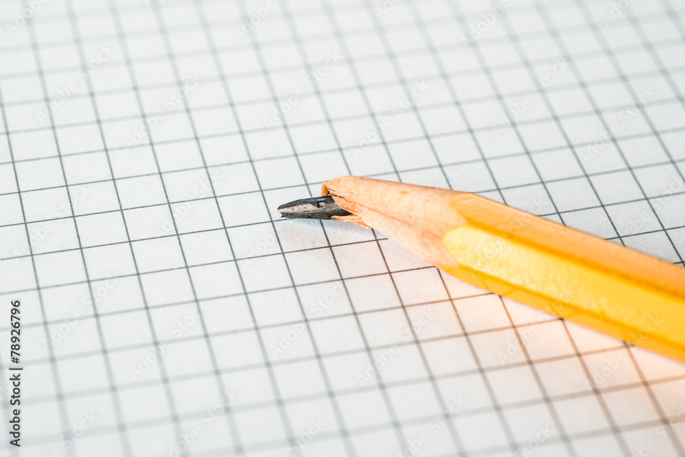 Broken pencil lying on a notepad Broken pencil lying on a notepad