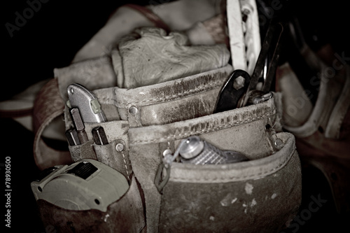 Rugged worn leather carpenters work bags with construction tools