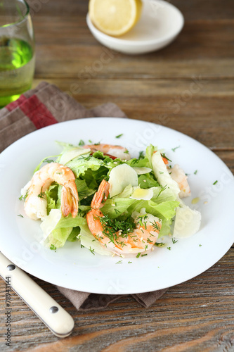 Delicious salad with shrimps, lettuce and cheese on a plate