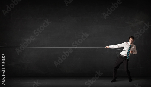 Businessman pulling rope on grey background © ra2 studio