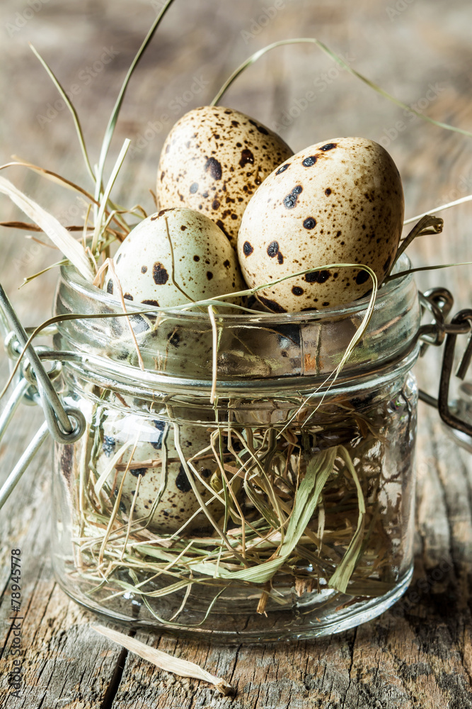 Easter - quail eggs with hay in a jar on an old vintage wood
