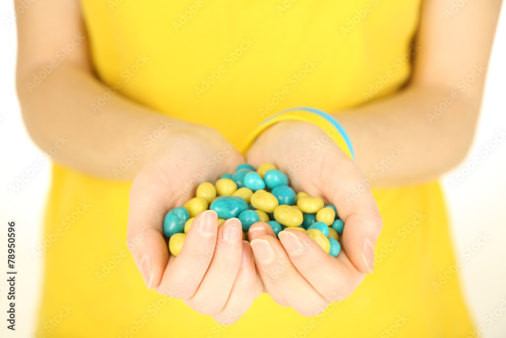Woman holding blue-yellow candies - colors of flag of Ukraine,