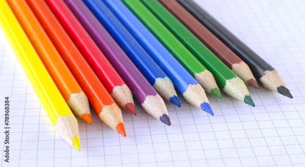 Color pencils on the checked paper of notepad Color pencils on the checked paper of notepad