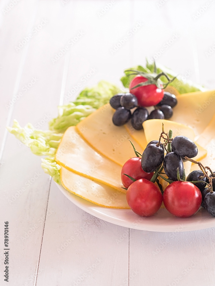 Käsescheiben mit Tomaten und Weintrauben Stock-Foto | Adobe Stock