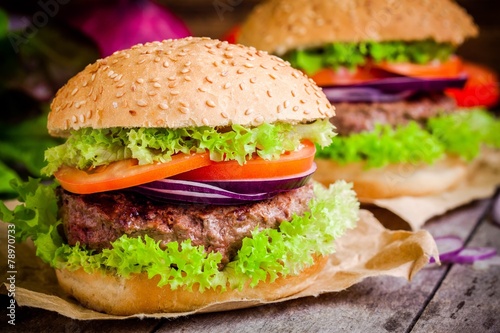 homemade hamburgers with green lettuce, tomatoes and red onions