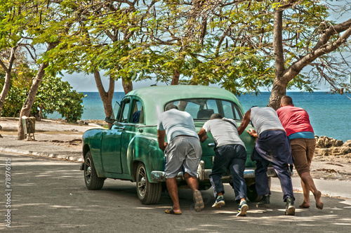 Ein Oldtimer wird am Playa La Boca Kuba angeschoben photo