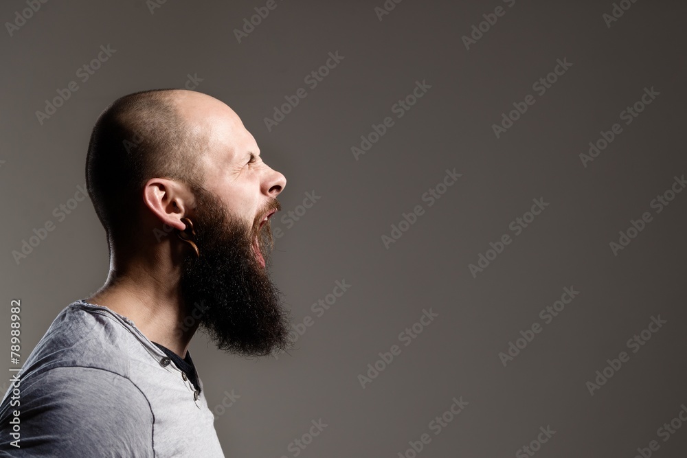 Fototapeta premium Side view portrait of screaming bearded man