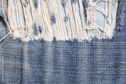 Closeup of tear in old jeans.
