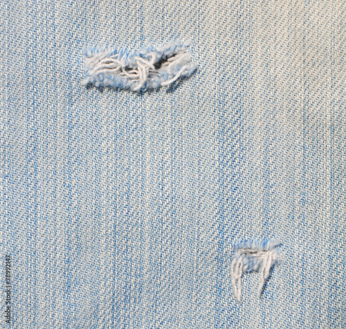 Closeup of tear in old jeans.