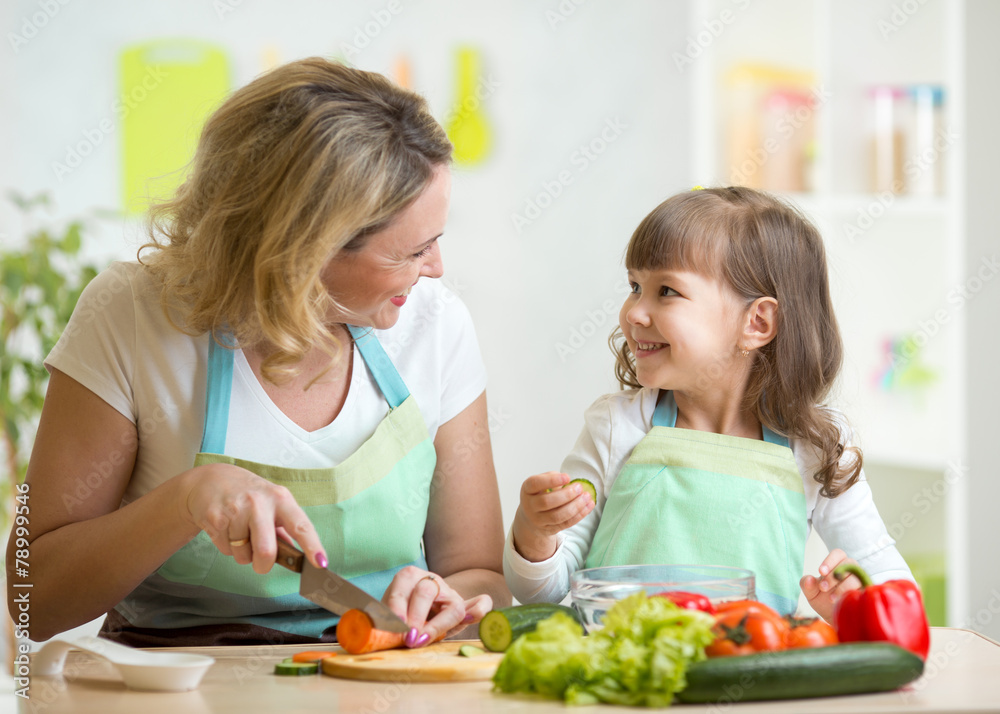 mother and daughter cooking and cutting vegetables on kitchen mother and daughter cooking and cutting vegetables on kitchen