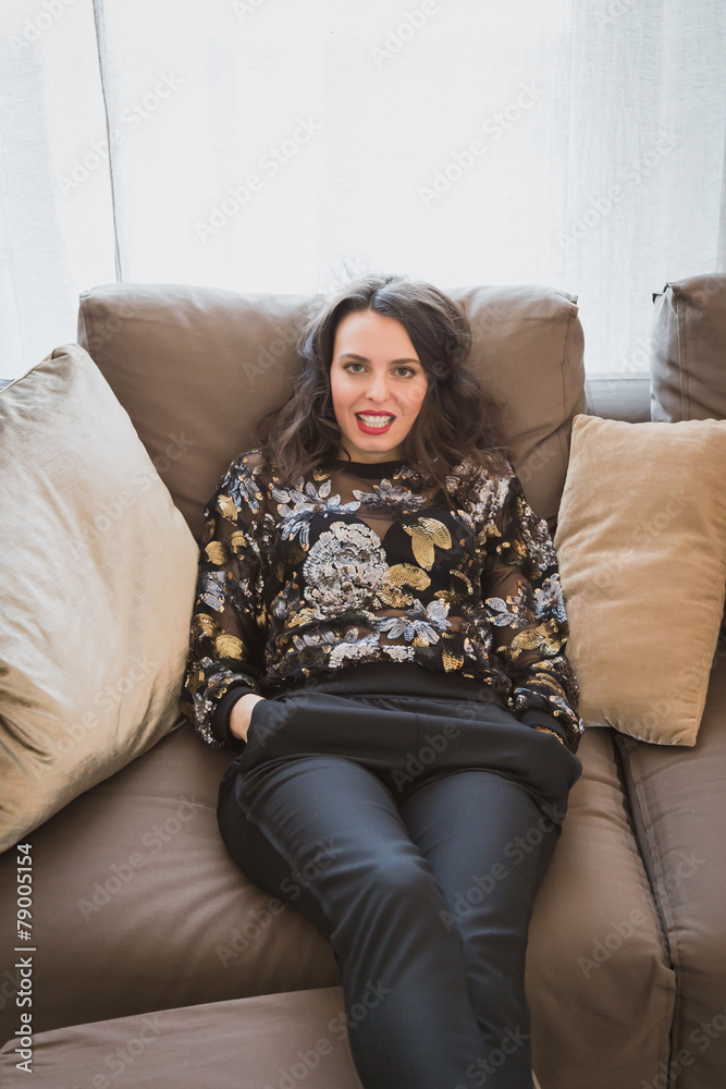 Fototapeta premium Beautiful young brunette relaxing on a couch
