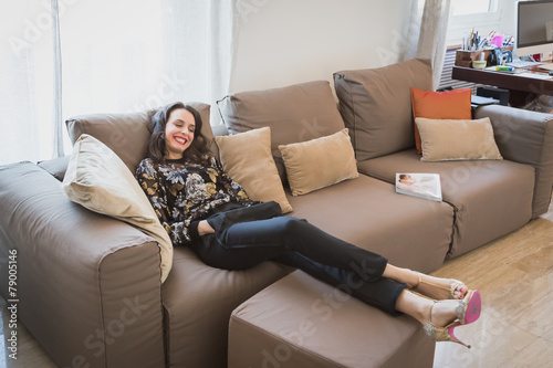 Beautiful young brunette relaxing on a couch