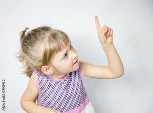 Pretty little girl indicating on something, white background