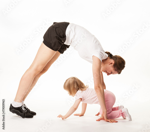 Happy mother and daughter doing sport exercises together.