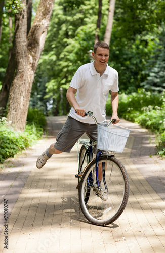 Happy young man riding on bicycle