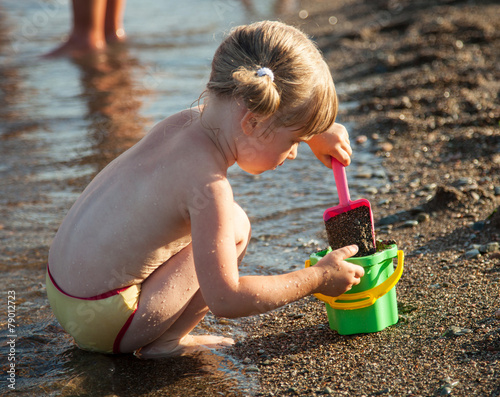 Little girl playing on the seashore