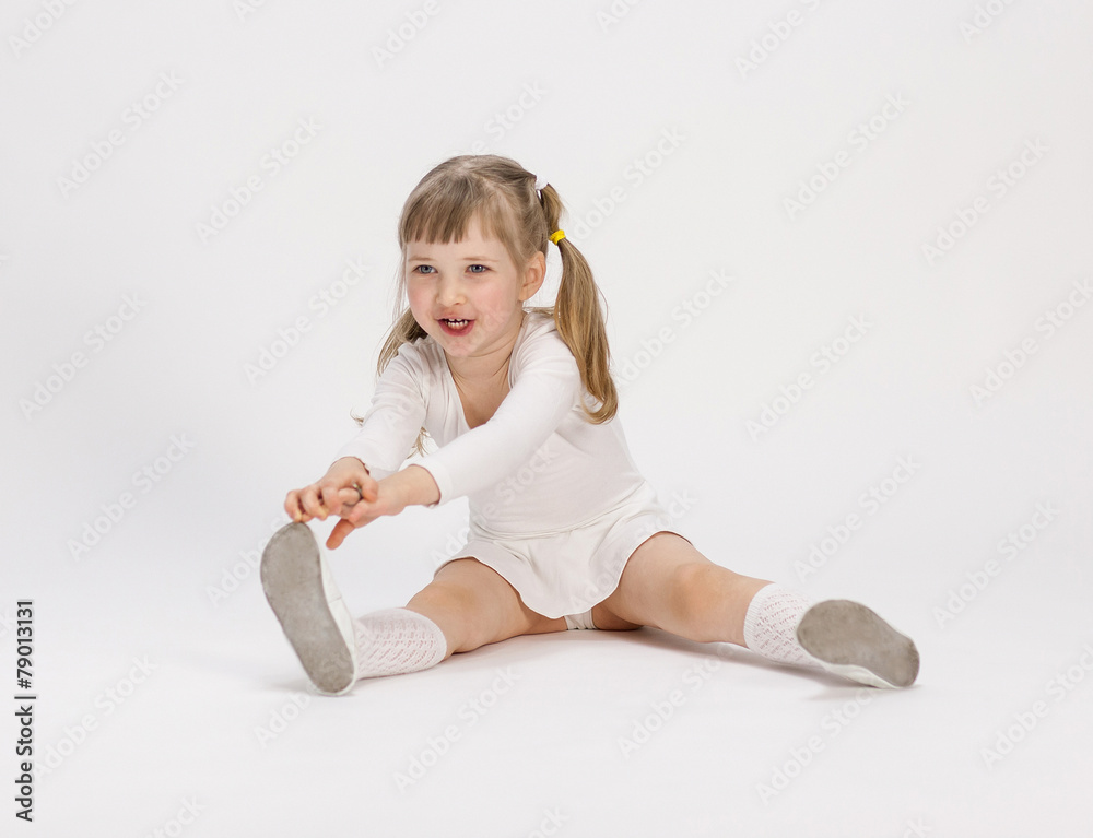 Pretty little girl sitting on the floor and doing exercise Pretty little girl sitting on the floor and doing exercise