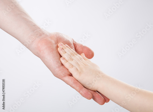 Hands of a child and a father touching each other