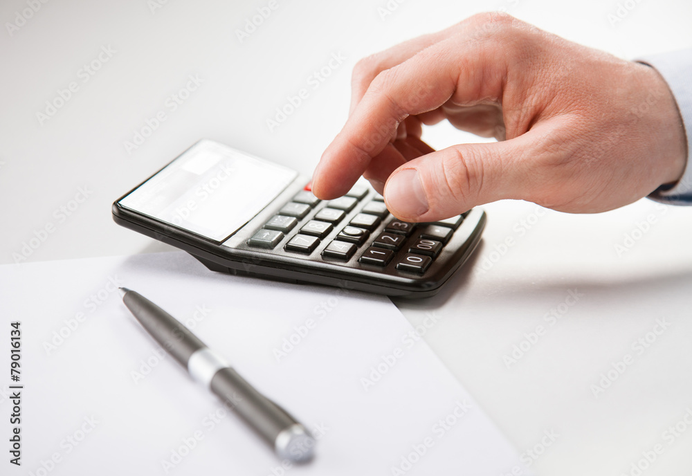 Hand of businessman using calculator Hand of businessman using calculator