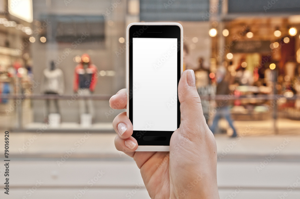 Smartphone with empty screen in woman hand in shopping center Smartphone with empty screen in woman hand in shopping center