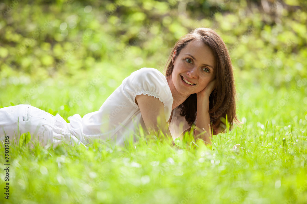 Beautiful girl lying on a green grass Beautiful girl lying on a green grass