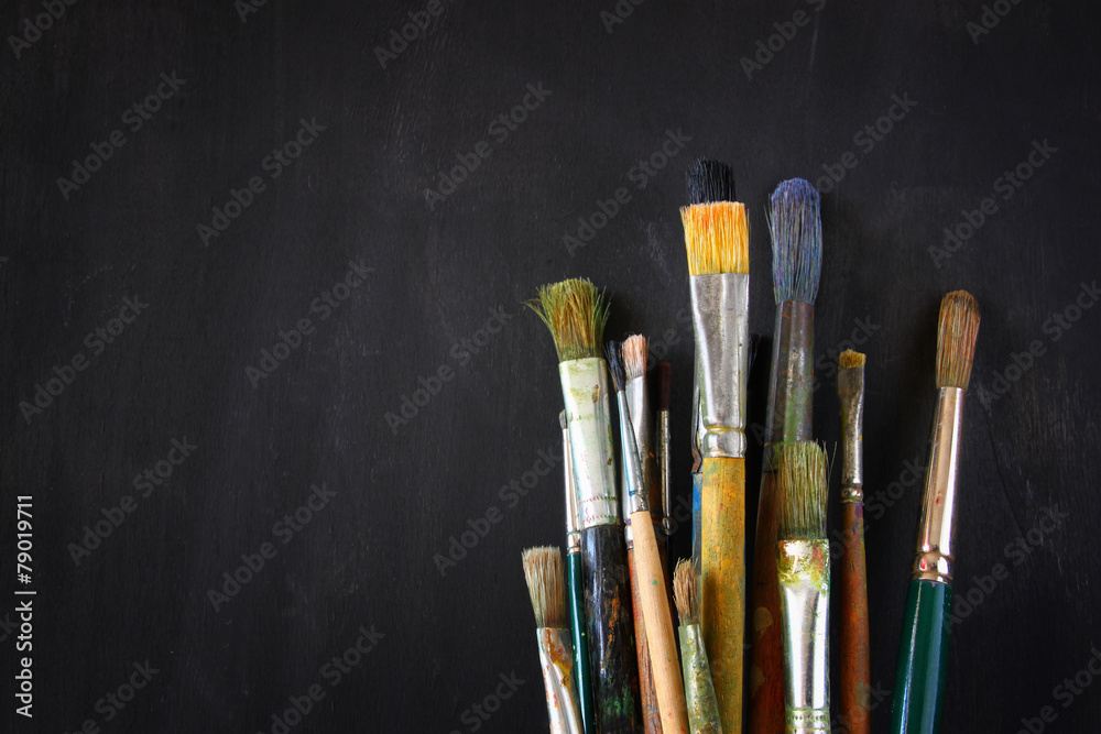 Fototapeta premium paint brushes in jar over blackboard background