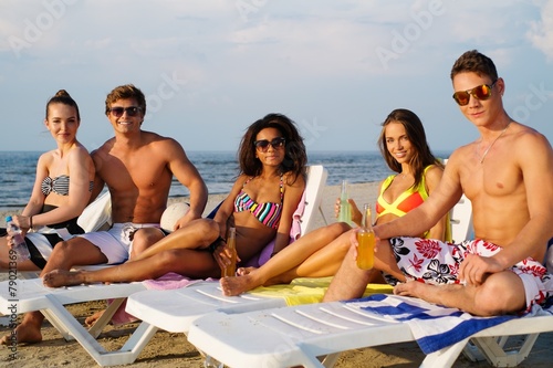 Group of multi ethnic friends relaxing on a beach 