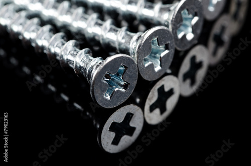 Screws on the black background. Macro shot.