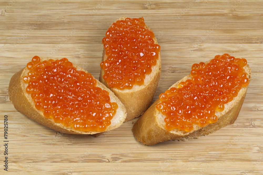 Sandwiches with red caviar on a wooden board Sandwiches with red caviar on a wooden board