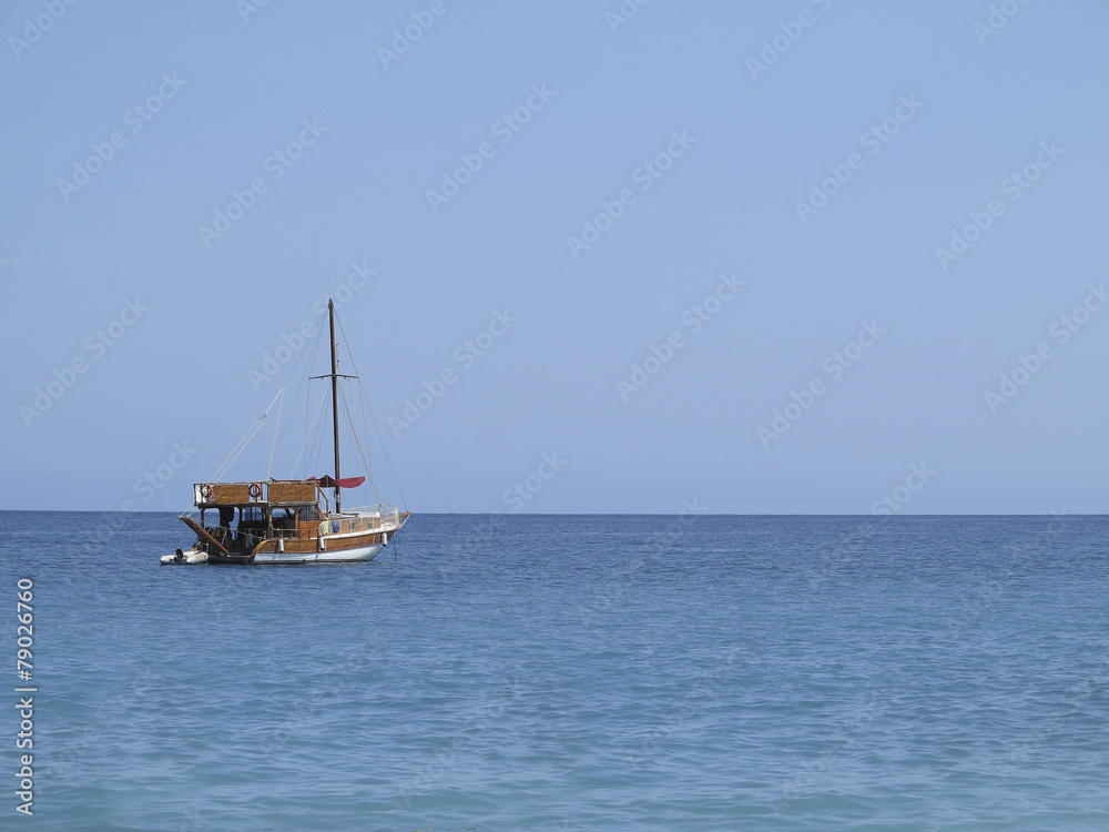 Old wooden fishing boat trawler over calm blue sea Old wooden fishing boat trawler over calm blue sea