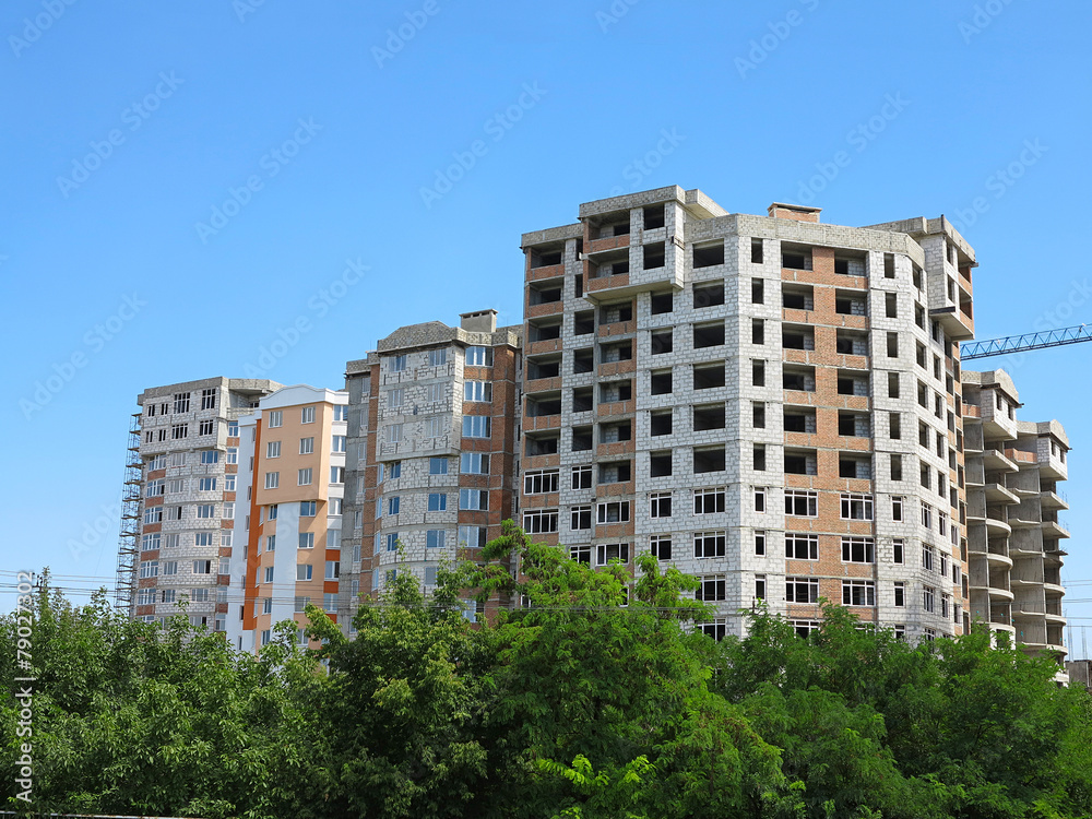 Residential modern apartment house, green forest and blue sky