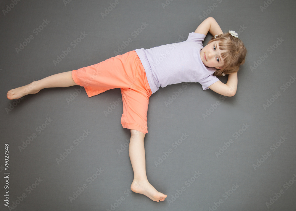 Smiling little girl lying on the floor Stock Photo | Adobe Stock