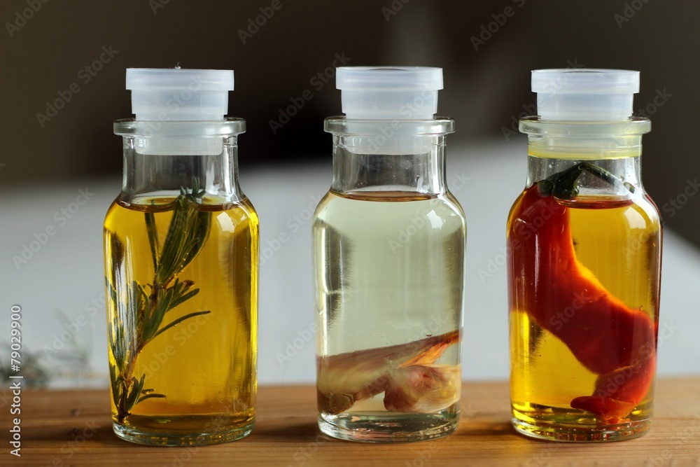 olive oil with pepper, lavender and garlic in glass bottles