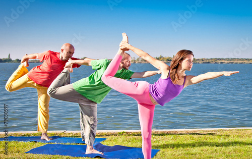 Tree people practice Yoga asana at lakeside. Yoga concept.