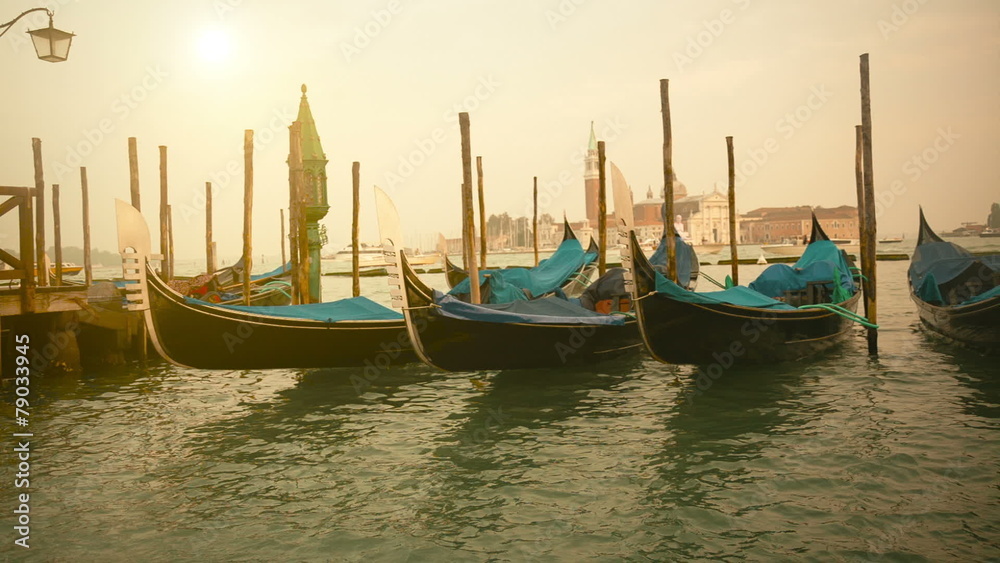 Venetian gondolas at sunrise tied near the pier Venetian gondolas at sunrise tied near the pier