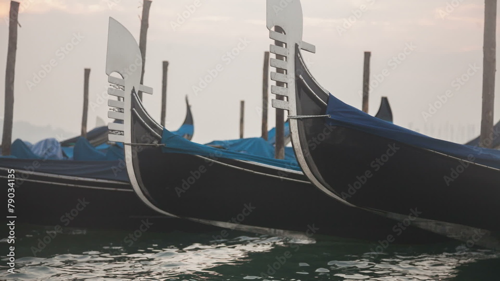 Venetian gondolas tied near the pier on San Marco square Venetian gondolas tied near the pier on San Marco square