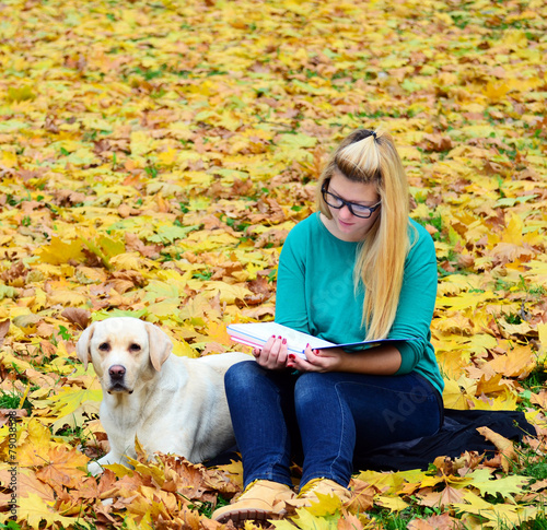 Girl with dog studying in nature