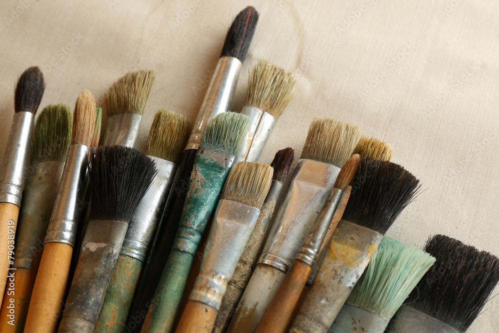 Fototapeta premium Different paintbrushes on fabric background