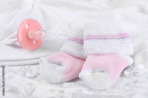 Pink baby socks on cloth close-up © Africa Studio