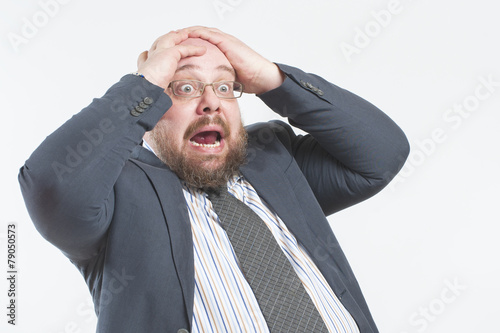 The man screams in horror holding his head..