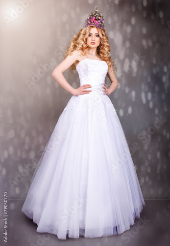 The bride in a white dress and a crown of flowers on her head